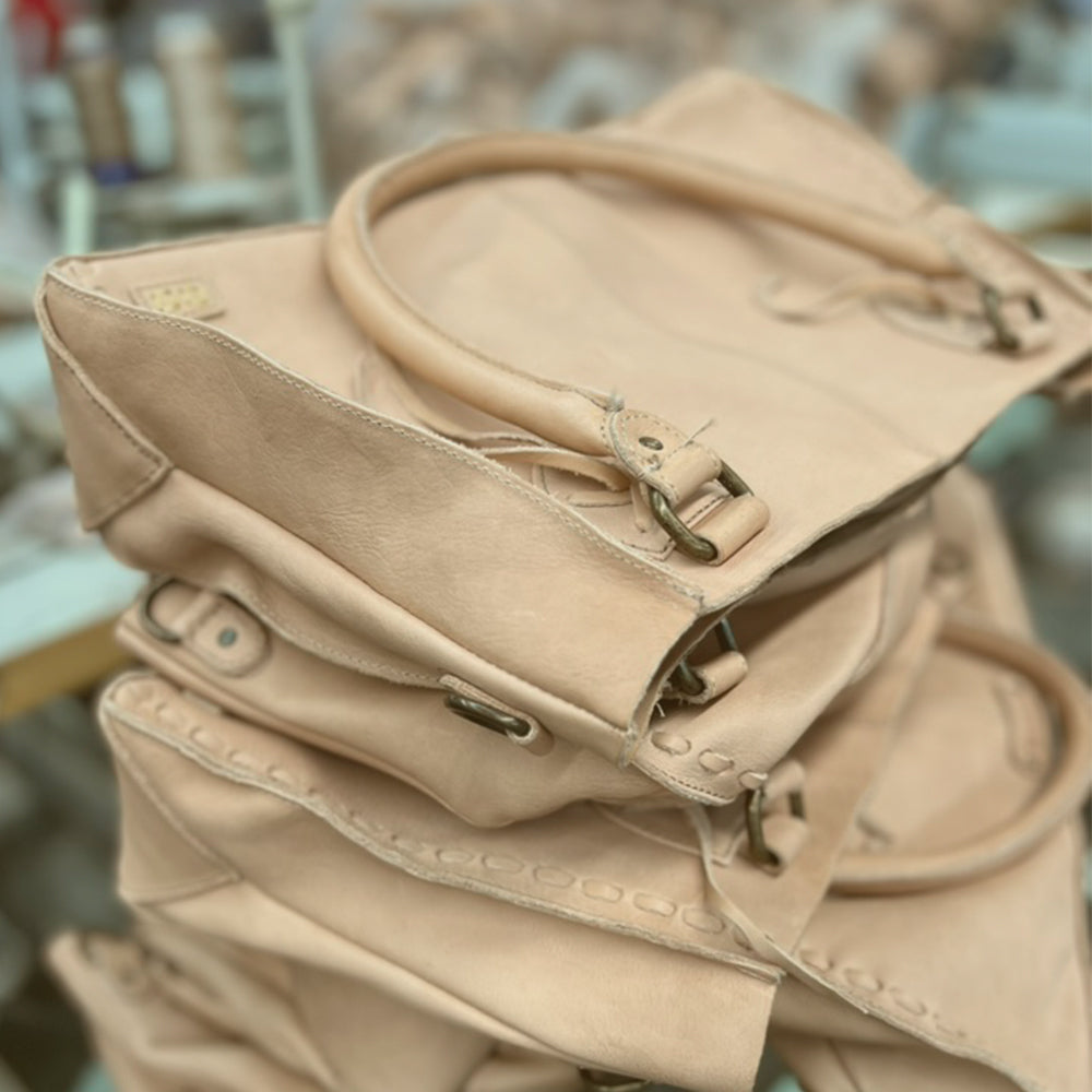 Stack of unfinished natural vegetable-tanned leather handbags in our workshop.