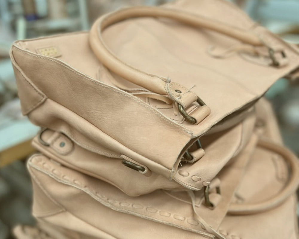 Stack of unfinished natural vegetable-tanned leather handbags in our workshop.
