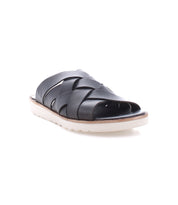 The Bed|Stü Abraham Light is a black leather slide sandal with crisscross straps and a white rubber sole, designed with a lightweight outsole for all-day comfort, shown at a slight angle on a white background.