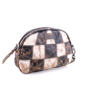 Introducing Abundance by Bed|Stü: a small rectangular pouch crafted from reclaimed, sustainable leather squares in brown, black, and white patchwork. This zippered pouch features a loop on one end and displays the Bed|Stü label prominently on the front.