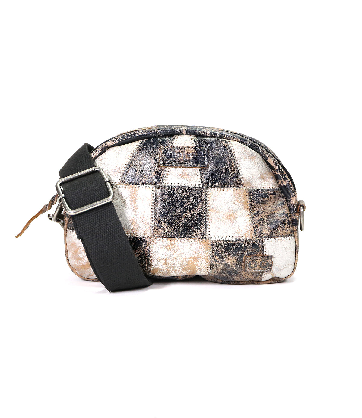 The Bed|Stü Abundance is a small crossbody bag with a black adjustable strap, showcasing a unique and sustainable patchwork design crafted from distressed black, brown, and white reclaimed leather squares.