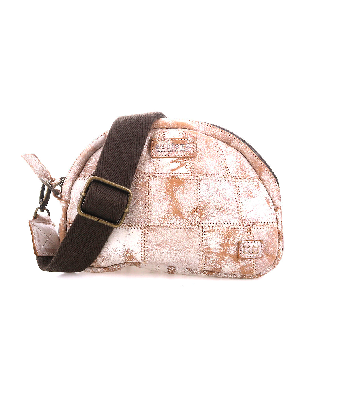 The Abundance by Bed|Stü is a small, sustainable fabric crossbody bag with a light brown and white patchwork pattern, featuring a dark brown adjustable strap crafted from reclaimed leather and finished with a zipper closure.