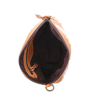 Top view of the Abundance crossbody bag by Bed|Stü, crafted from reclaimed brown leather. The bag features a black interior lining, zipper closure, a small inside side pocket, and a metal ring attached to one corner. The interior is empty.