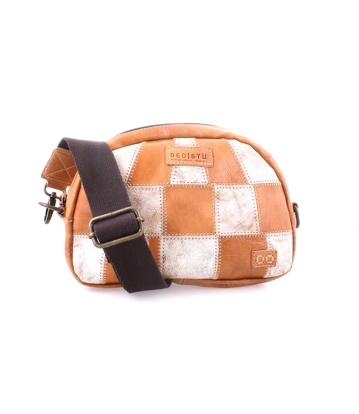 The Bed|Stü Abundance is a small crossbody bag crafted from reclaimed leather, showcasing a brown and white patchwork design and finished with a dark adjustable fabric strap, all set against a white background for an eco-friendly, stylish appearance.