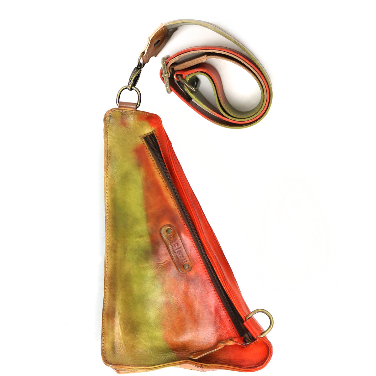 Introducing the Adept by Bed|Stü—a triangular compact sling crafted from vegetable-tanned leather, showcasing a diagonal zipper and a striking gradient of green, yellow, and red hues. The adjustable multicolored strap secures with sturdy metal rings, combining style and versatility in one elegant design.