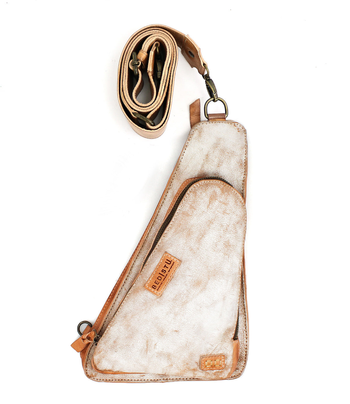 The Bed|Stü Adept is a compact sling crafted from tan and white vegetable-tanned leather, featuring an attached zippered pocket and shown with its adjustable strap coiled above the bag on a white background.
