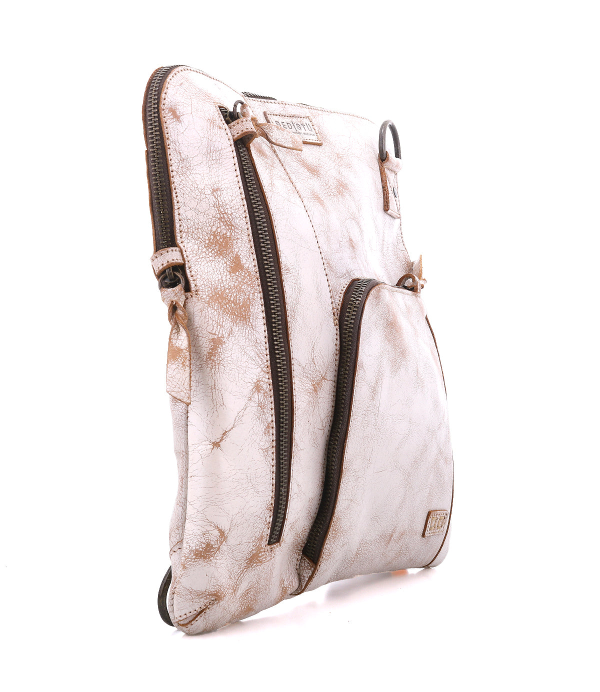 The Bed|Stü Aiken is a light brown, distressed full-grain leather crossbody bag featuring two zippered compartments and an adjustable strap, shown standing upright on a white background.