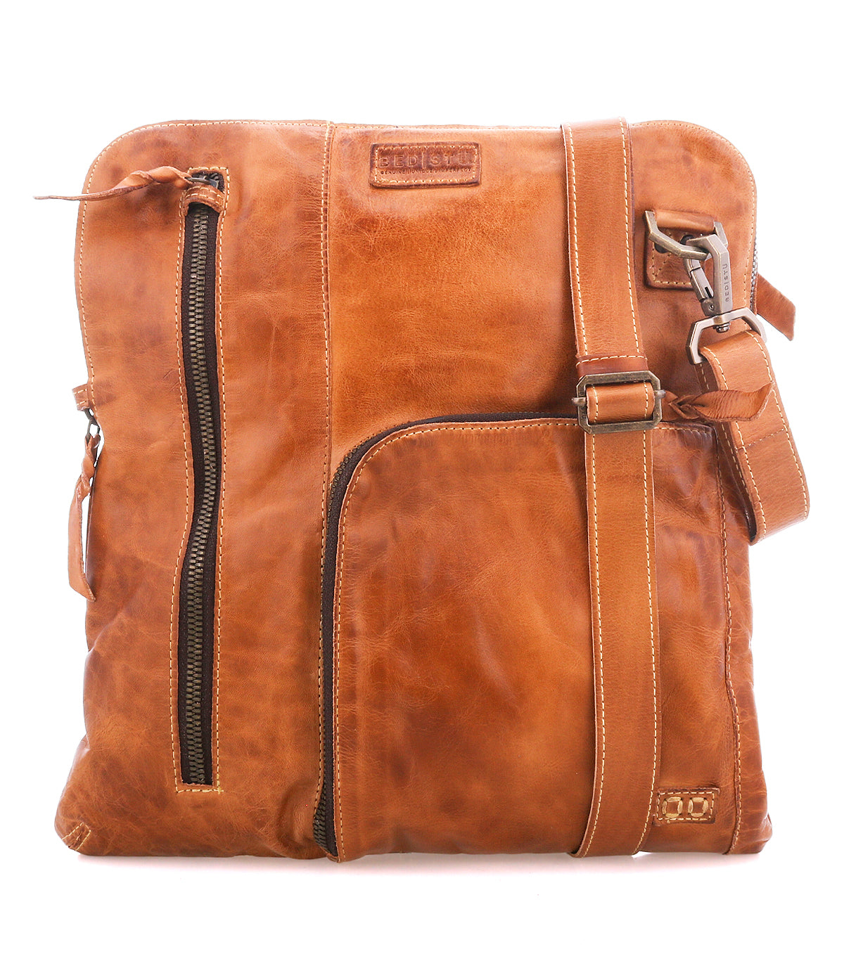 The Bed|Stü Aiken crossbody bag is crafted from full-grain leather and features an adjustable strap, front zipper pockets for easy access, and a stitched logo patch near the top. For added peace of mind while you're on the go, it also includes anti-theft security features.