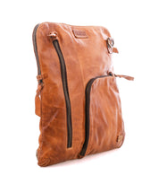 Bed|Stü’s Aiken is a tan full-grain leather shoulder bag, shown against a white background. It features two visible zippered pockets—one vertical and one diagonal—and an adjustable strap for comfortable carrying.
