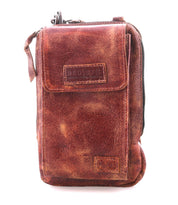 The Bed|Stü Alelike is a brown distressed leather crossbody bag featuring a front flap, right-side zipper, and visible stitching—ideal for carrying travel essentials. This compact purse is photographed against a white background.