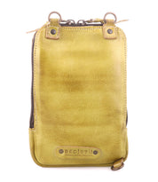 The Alelike by Bed|Stü is a small rectangular yellow leather pouch featuring a zipper closure, metal rings, and a "Bed|Stü" branded leather patch at the bottom front—making this compact purse ideal for carrying travel essentials or styling as a chic leather crossbody.