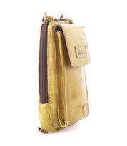 The Alelike by Bed|Stü is a small, rectangular crossbody bag crafted from light green leather with a textured surface, visible zippers, and a front flap. Standing upright against a white background, this compact purse is perfect for keeping your travel essentials organized and stylishly within reach.