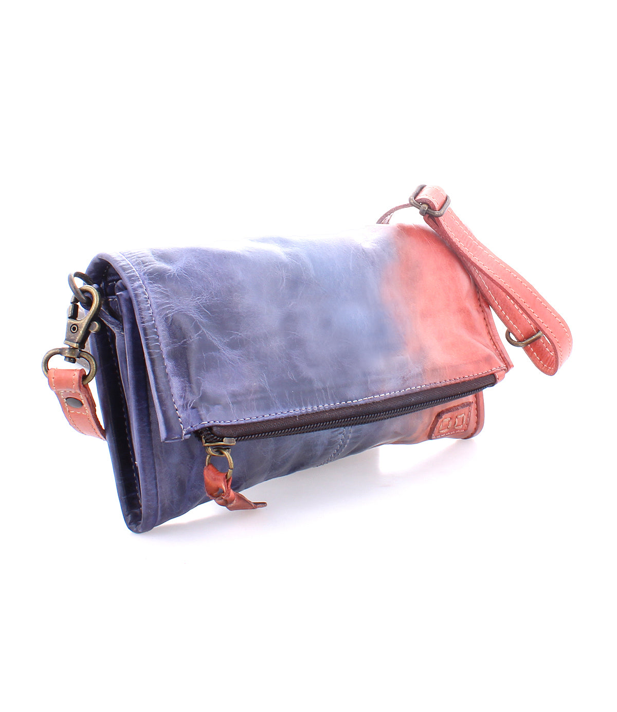 The Amina clutch by Bed|Stü showcases a striking blue and pink ombre pattern, accented with a pink strap, brass hardware, and a front zipper pocket. Photographed on a white background, this versatile bag seamlessly transforms from a fold-over clutch to a convenient crossbody.