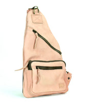 The Andie sling bag by Bed|Stü, crafted from light pink leather, features an adjustable strap and multiple zippered pockets, and is displayed upright against a white background.