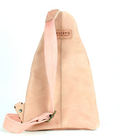 Light pink leather sling bag called "Andie" by Bed|Stü, featuring an adjustable sturdy fabric strap, vertical stitching details, and a rectangular "Bed|Stü" patch on the front, photographed against a white background.