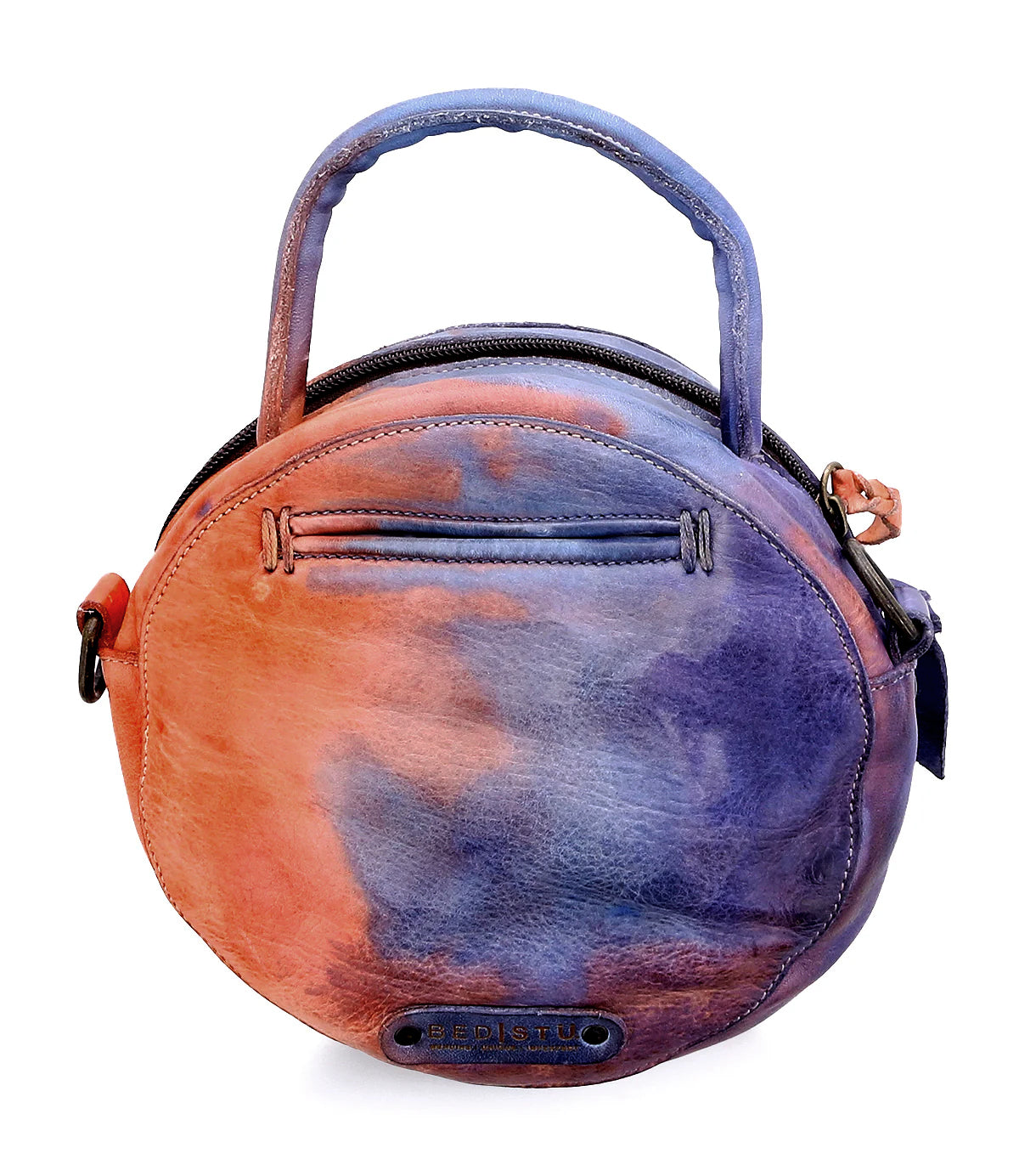 The Arenfield by Bed|Stü is a round leather crossbody bag with a top handle and an adjustable strap. It features a zip-top closure, an interior zipper pocket, and a striking gradient blend of orange, purple, and blue hues.