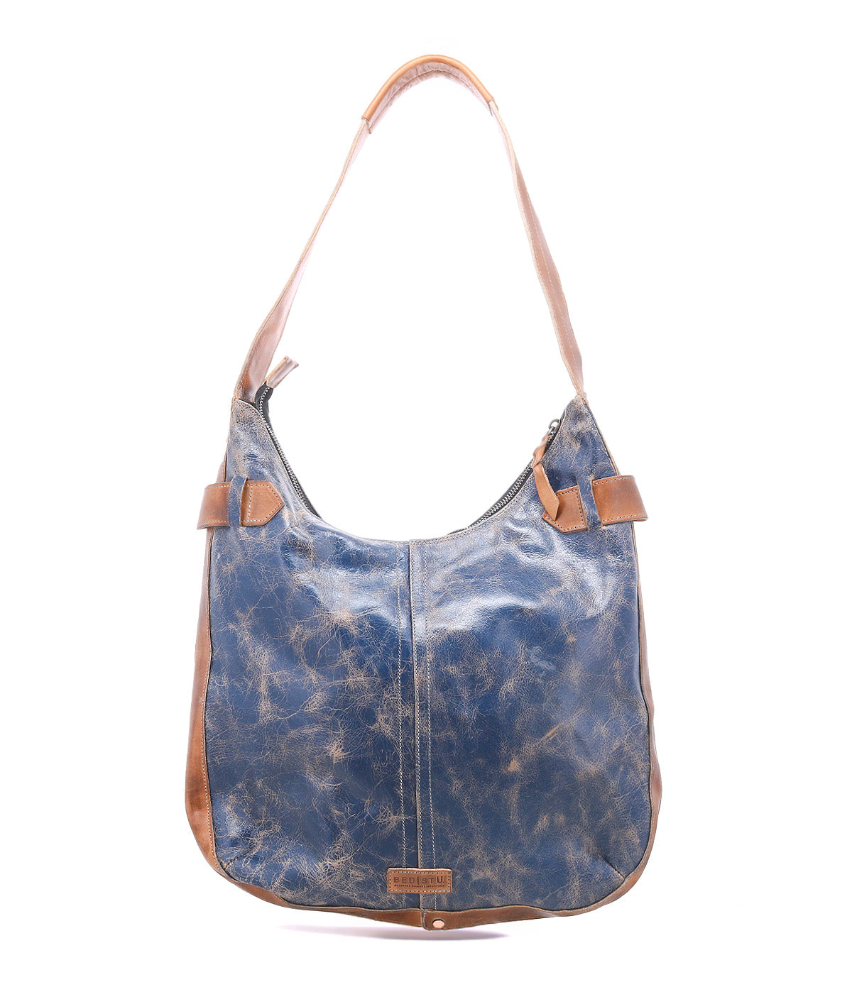 The Bed|Stü Argus is a blue and brown handcrafted leather shoulder bag featuring a single strap, visible stitching, and a slightly distressed finish. Photographed against a white background, this patchwork leather bag brings unique character to any outfit.