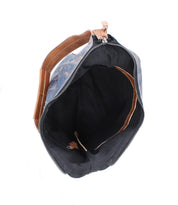 Top view of the Bed|Stü Argus bag, featuring an open blue and brown patchwork leather design with a zipper, revealing a spacious black interior and an inner brown pocket.