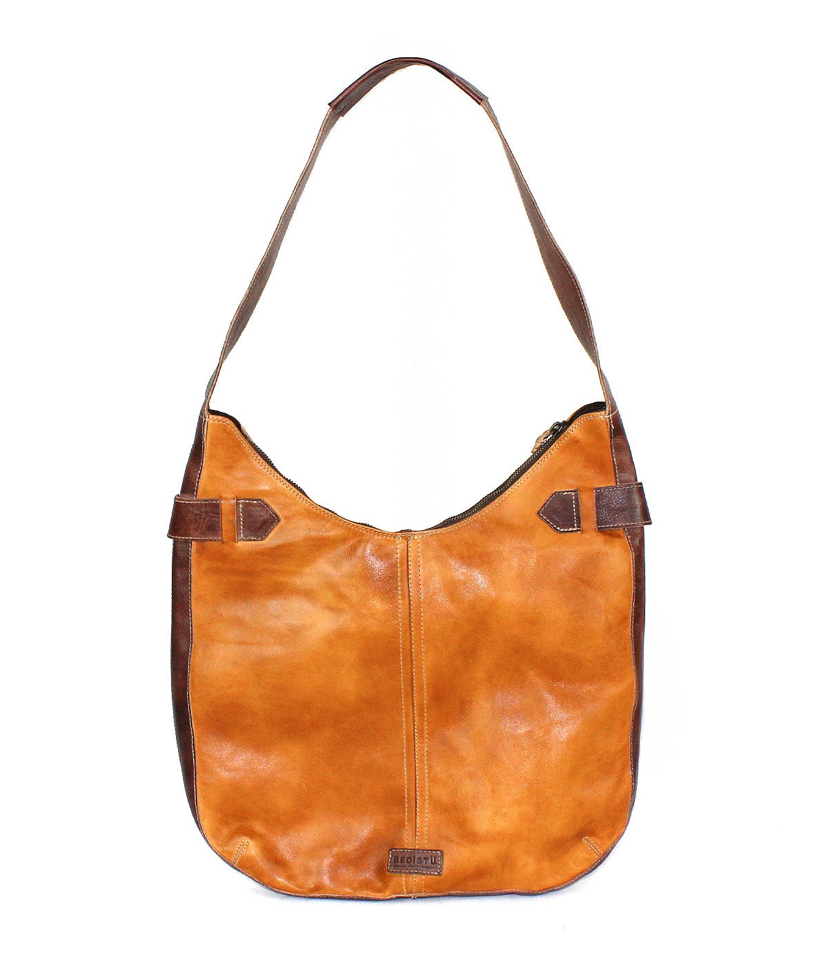 The Bed|Stü Argus is a brown patchwork leather bag with a wide strap and darker brown side accents, featuring oversized front pockets, shown against a white background.