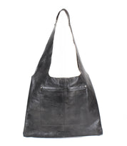 The Ariel II by Bed|Stü is a black leather tote shoulder bag featuring a wide strap and a large front pocket, shown against a white background. This spacious tote blends modern style with everyday functionality.