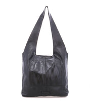 The Ariel Max by Bed|Stü is a large, hand-finished black leather shoulder bag with wide straps and two front pockets, offering a spacious interior. It is photographed against a white background.