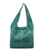 The Bed|Stü Ariel Max is a large teal oversized tote shoulder bag crafted with hand-finished leather, featuring a square front pocket and wide strap, displayed against a white background. Designed for both style and function, the Ariel Max offers a spacious interior—perfect for carrying all your essentials.