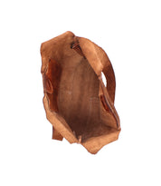 Top view of the Bed|Stü Ariel Mid, an empty brown artisanal shoulder bag crafted from suede with visible pockets and handle, isolated on a white background.