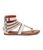 The Artemis II by Bed|Stü is a metallic silver gladiator sandal with multiple leather straps, a buckle closure, toe loop, and a flat brown sole, displayed in side profile.