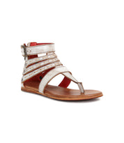 Introducing the Artemis II by Bed|Stü—a flat brown gladiator sandal with metallic silver leather straps, an ankle buckle closure, and an open toe design, showcased against a white background.