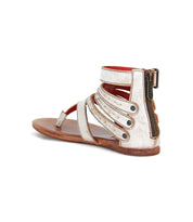 The Artemis II by Bed|Stü is a metallic silver gladiator sandal featuring multiple leather straps, a back zipper, and a flat brown sole, shown from the rear side angle.