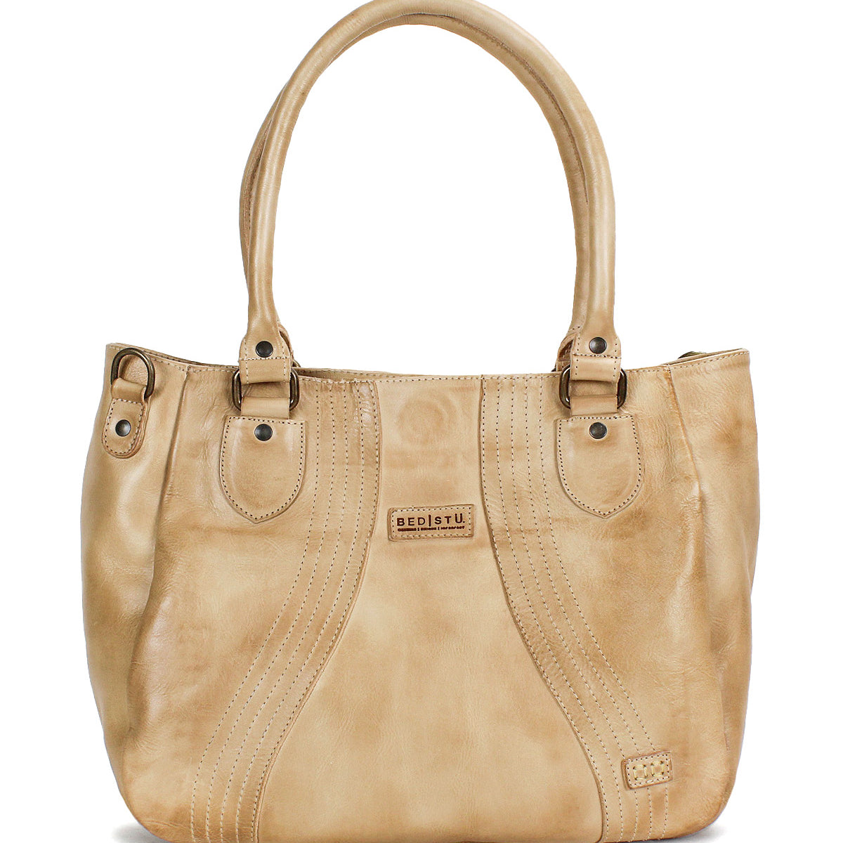 The Astana by Bed|Stü is a beige leather handbag featuring two handles, decorative stitching, metal studs, and a small rectangular brand patch on the front—this modern accessory draws inspiration from the classic vintage bowling bag design and is perfect for everyday use.