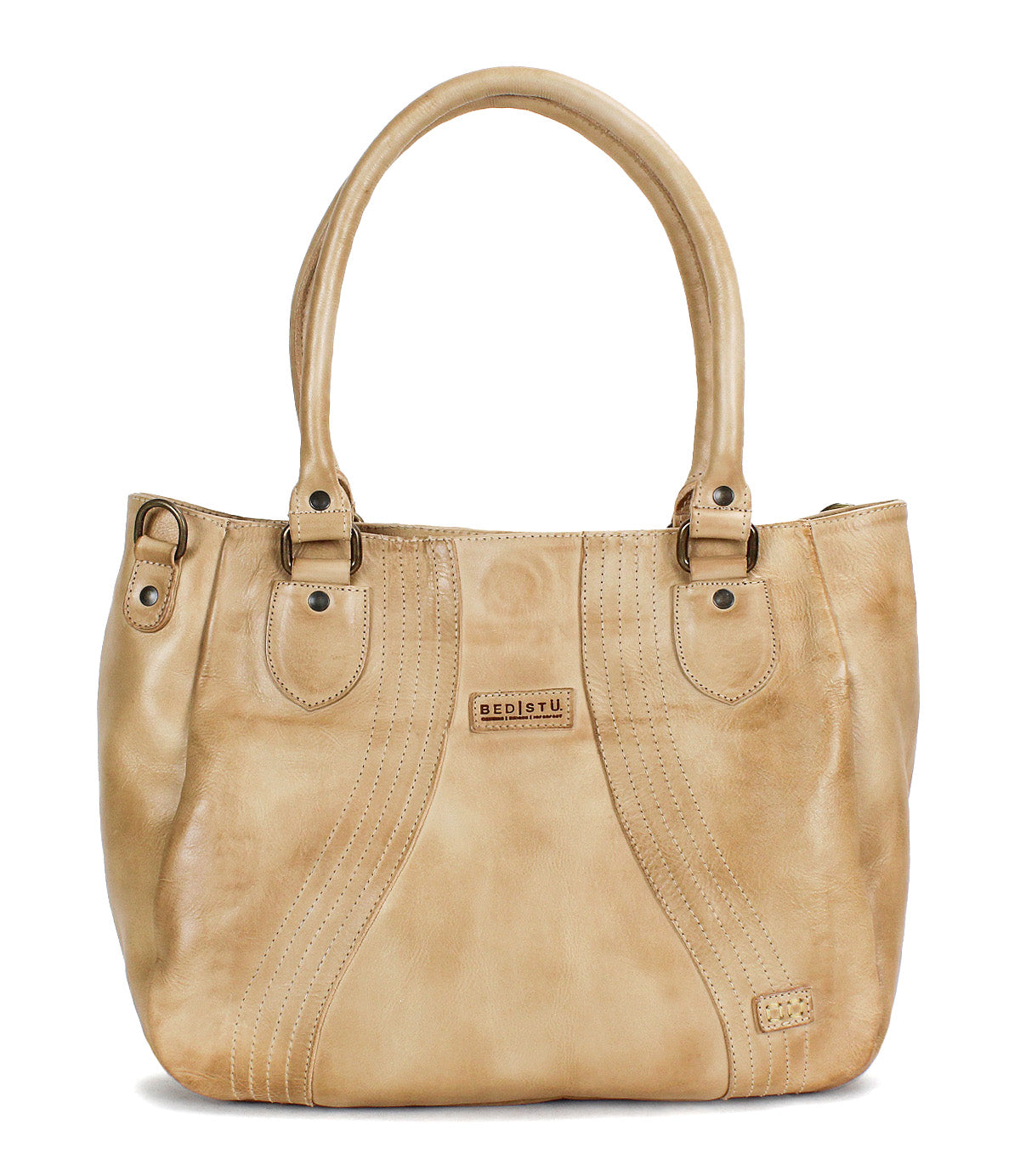 The Astana by Bed|Stü is a beige leather handbag featuring two handles, decorative stitching, metal studs, and a small rectangular brand patch on the front—this modern accessory draws inspiration from the classic vintage bowling bag design and is perfect for everyday use.