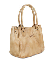 The Astana handbag by Bed|Stü features tan leather, dual handles, decorative stitching, and a small brand label on one side. This modern accessory is photographed against a white background.