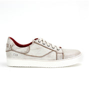 The Bed|Stü Azeli is a white leather sneaker featuring brown stitching, white laces, and a red interior, presented in a side profile view against a plain white background. Designed for all-day comfort, this casual shoe is also equipped with a durable rubber outsole.