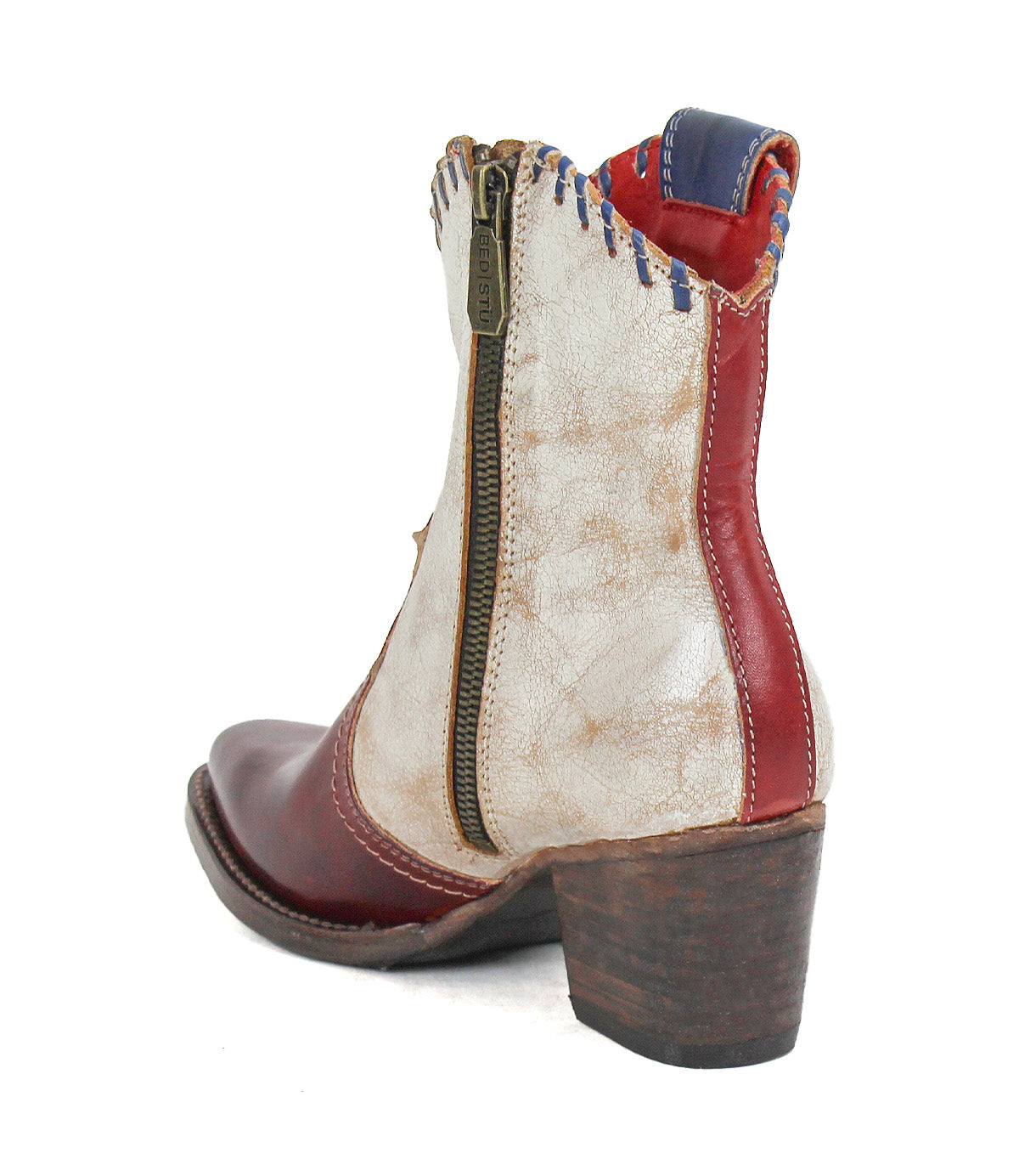 Introducing the Baila II by Bed|Stü—a Western-inspired ankle boot featuring a pointed toe, convenient side zipper, bold red and white panels with blue stitching, and artisanal craftsmanship atop a stacked wooden heel.