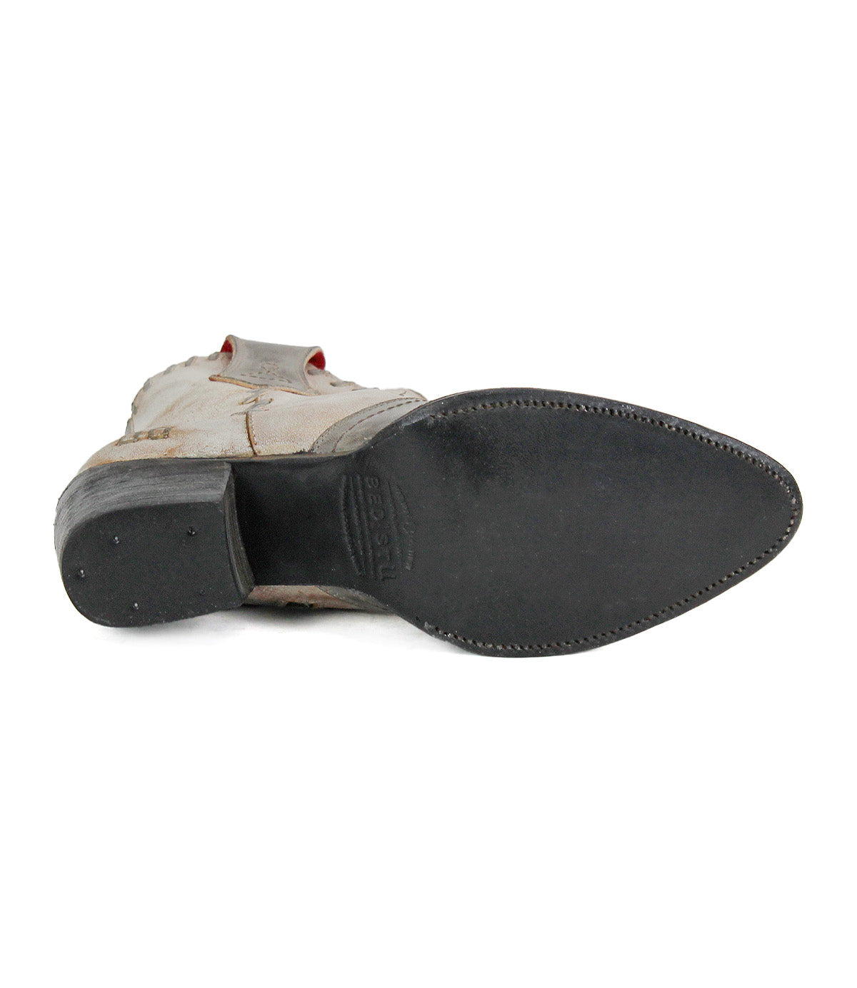 A close-up view of the bottom of a single Baila II cowboy boot by Bed|Stü, showcasing a black leather sole with artisanal construction, featuring a pointed toe and a small heel.