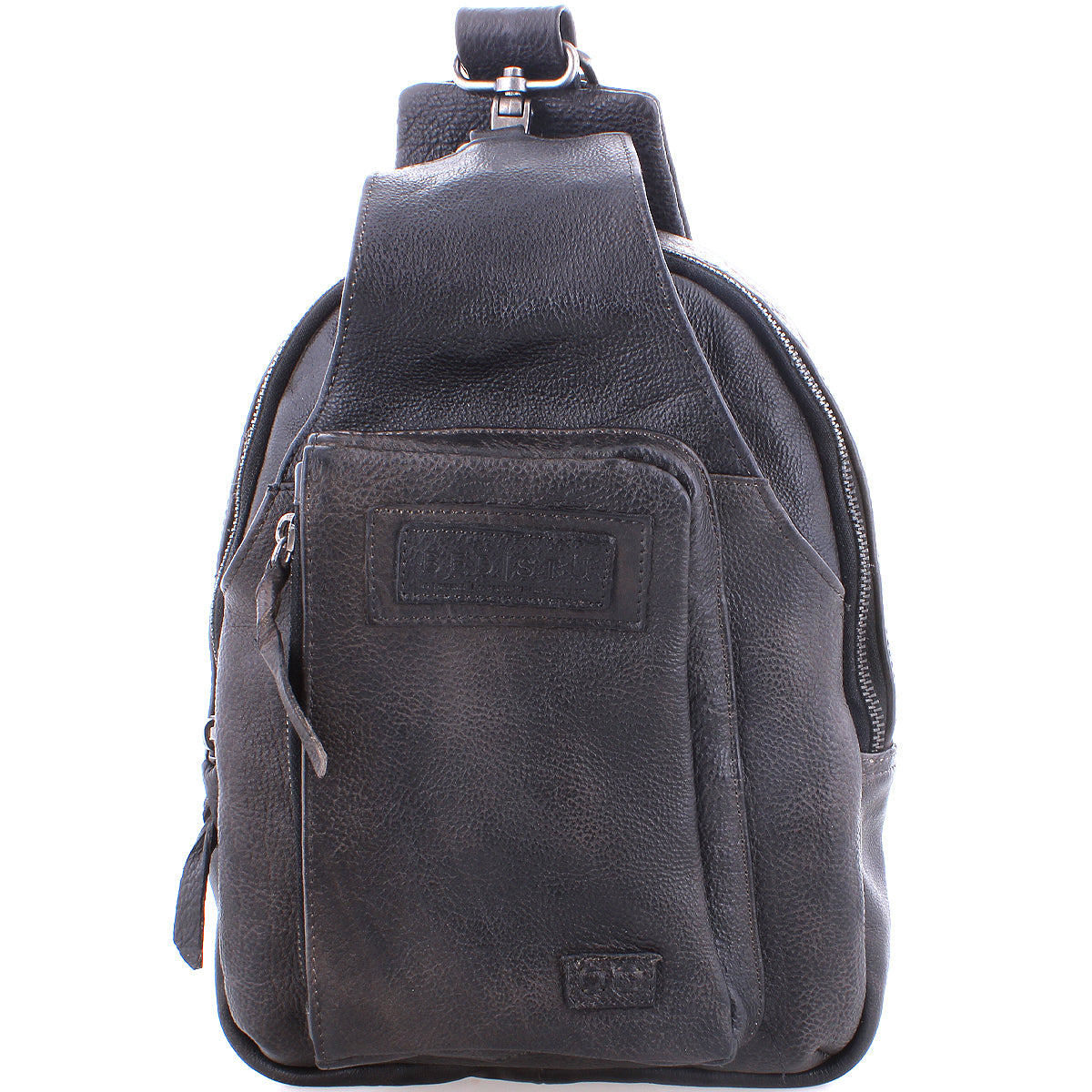 The Beau by Bed|Stü is a black leather sling backpack featuring a zipper front pocket and a top handle, photographed against a white background. This compact bag combines the versatility and convenience of a modern leather sling, making it perfect for everyday use.
