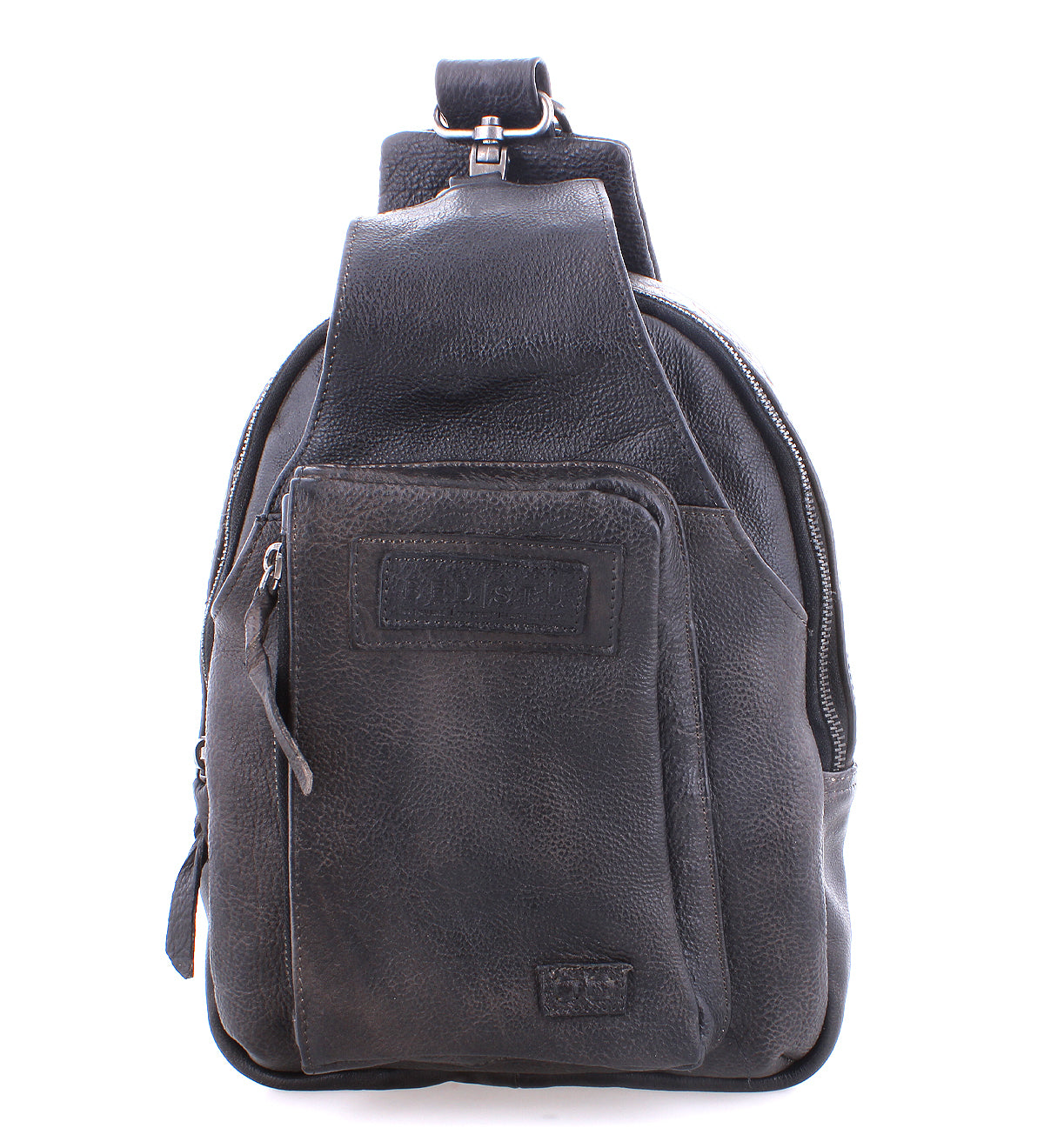 The Beau by Bed|Stü is a black leather sling backpack featuring a zipper front pocket and a top handle, photographed against a white background. This compact bag combines the versatility and convenience of a modern leather sling, making it perfect for everyday use.