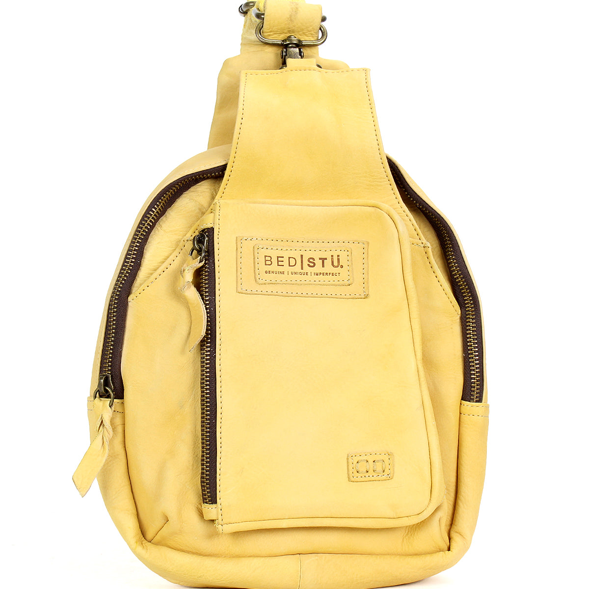 Introducing the Beau by Bed|Stü—a small yellow leather sling bag featuring two zippered compartments and a signature front patch. This compact backpack is ideal for carrying your essentials with stylish ease.