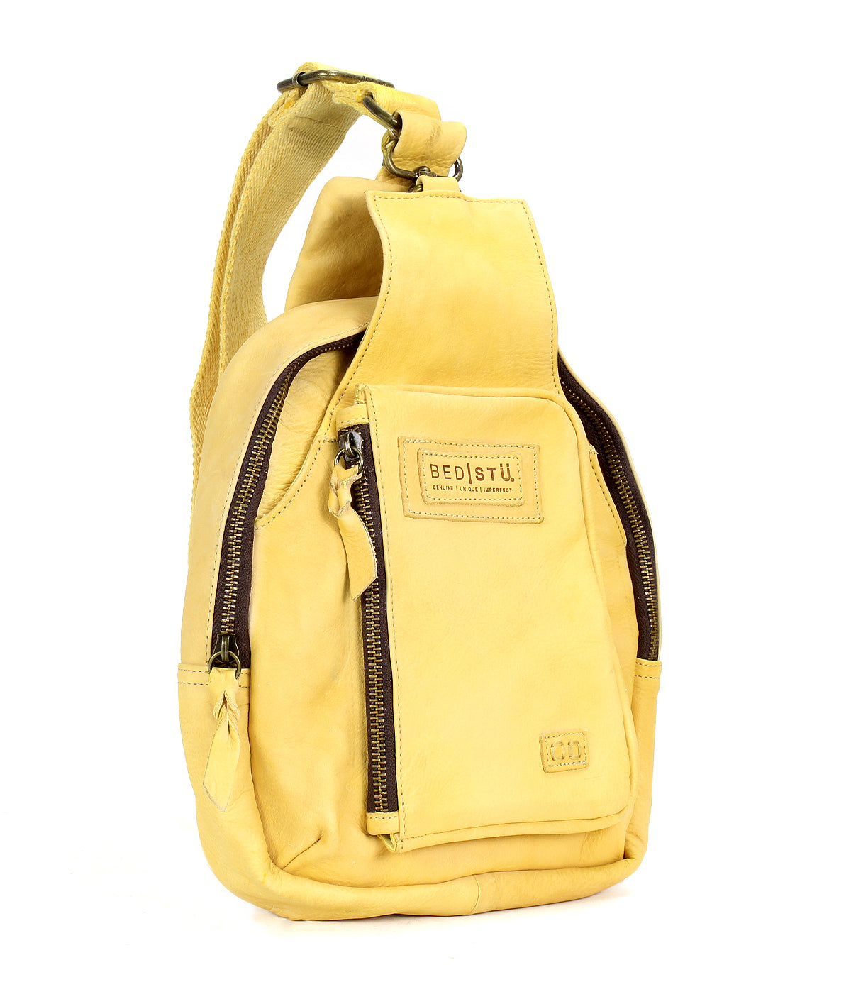 The "Beau" by Bed|Stü is a yellow leather sling bag featuring a front zipper pocket, branded label, and a single adjustable shoulder strap—blending hands-free practicality with the sophistication of premium leather.