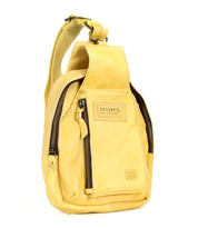The "Beau" by Bed|Stü is a yellow leather sling bag featuring a front zipper pocket, branded label, and a single adjustable shoulder strap—blending hands-free practicality with the sophistication of premium leather.
