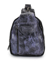 A small Beau sling backpack by Bed|Stü in dark purple and black leather, featuring a front zipper pocket and a stitched Bed|Stü brand label on the front.