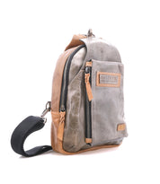 A two-tone brown and gray leather crossbody sling bag named "Beau" from Bed|Stü, featuring front and main zippered compartments and a branded patch, displayed against a white background.