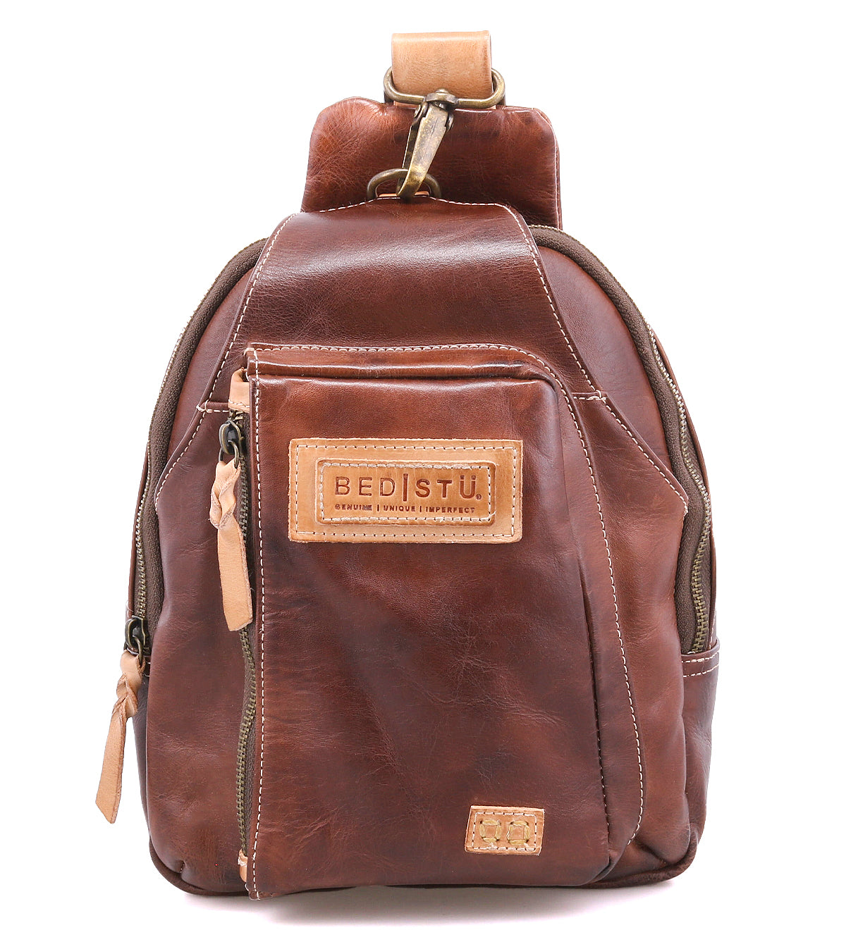 A small brown leather sling backpack called the "Beau" by Bed|Stü, featuring a front zipper pocket, tan leather zipper pulls, and a stitched "BED|STU" label on the front.