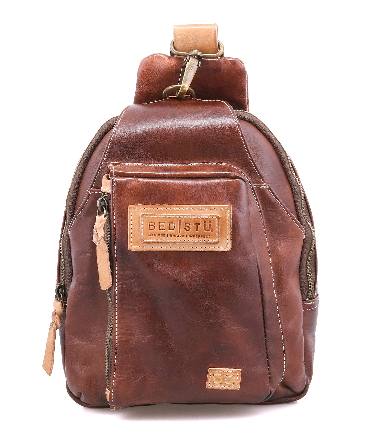 A small brown leather sling backpack called the "Beau" by Bed|Stü, featuring a front zipper pocket, tan leather zipper pulls, and a stitched "BED|STU" label on the front.