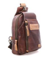The Beau backpack by Bed|Stü features brown leather construction with multiple zippered compartments, tan stitching, and a prominent Bed|Stü brand patch on the front. This compact sling backpack blends style and functionality for everyday convenience.