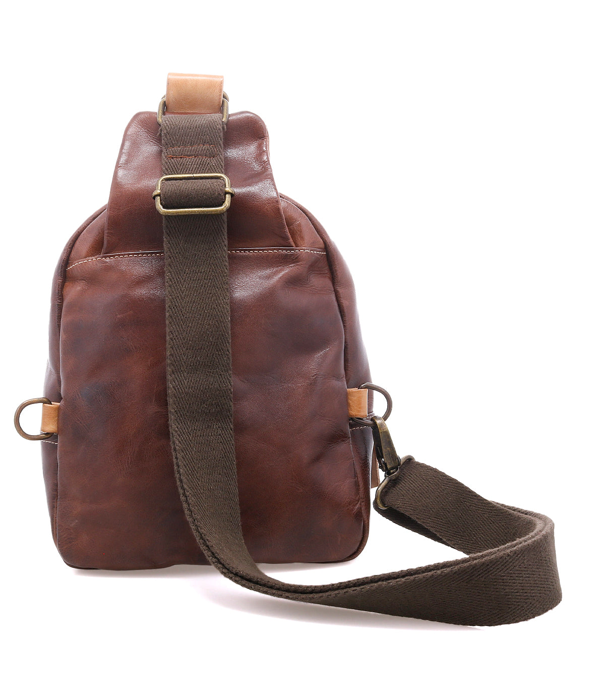 The Beau sling bag by Bed|Stü, crafted from brown leather and featuring an adjustable dark brown fabric strap, brass buckles, and two side rings, is pictured from the back against a white background—this compact yet stylish leather backpack is a versatile solution for carrying your everyday essentials.