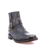 The Becca boot by Bed|Stü is displayed on a white background, featuring a single black leather design with a sturdy ankle buckle, side zipper, and a worn, distressed finish.