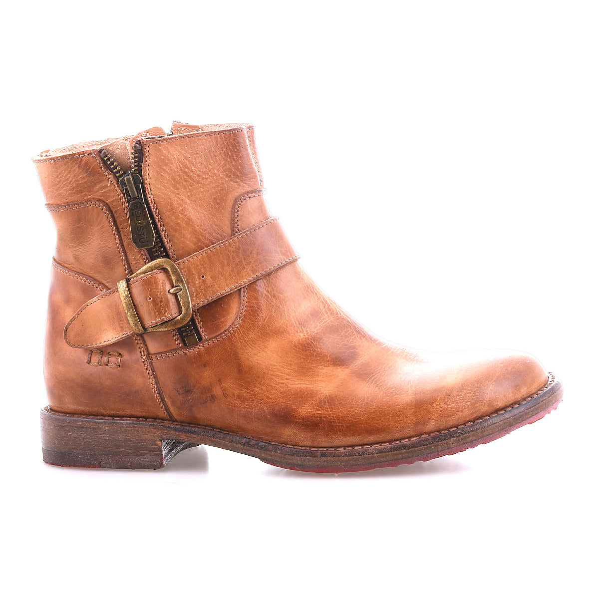 The Becca by Bed|Stü is a brown leather ankle boot with an ankle buckle, side zipper, and low heel. Featuring a sturdy leather shaft reminiscent of a classic engineer boot, it is shown in profile against a white background.