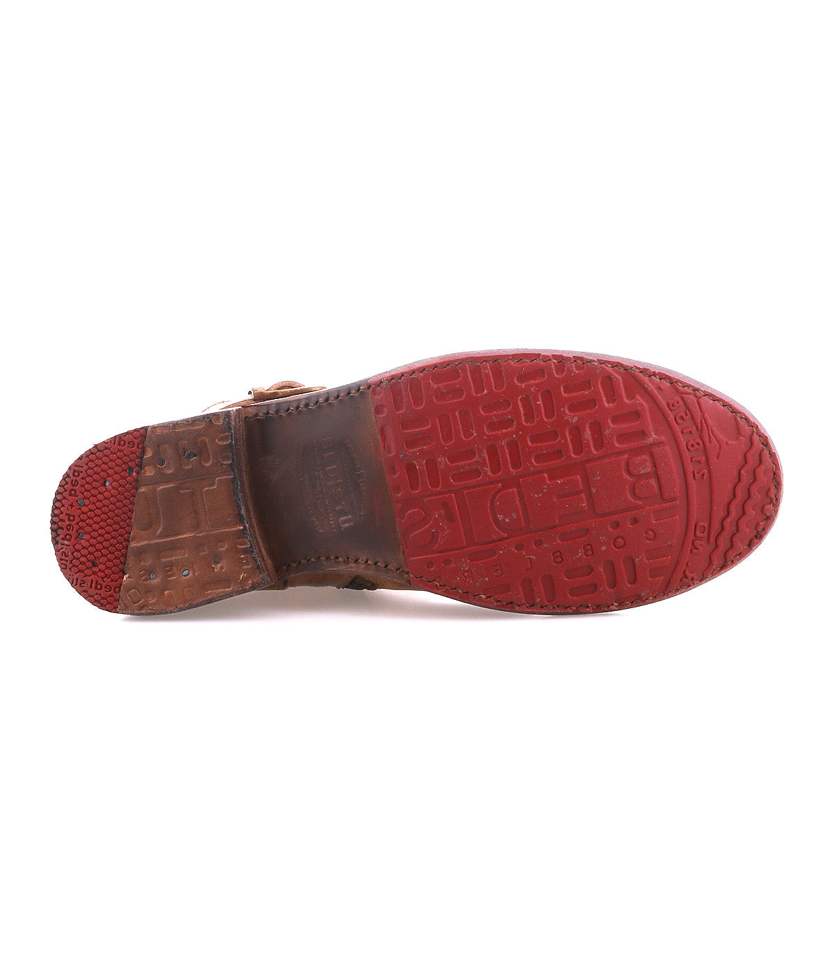 Bottom view of the Becca by Bed|Stü: a brown dress shoe featuring a red, patterned rubber sole and a partially visible leather midsole, combining sturdy construction reminiscent of an engineer boot with a refined design.